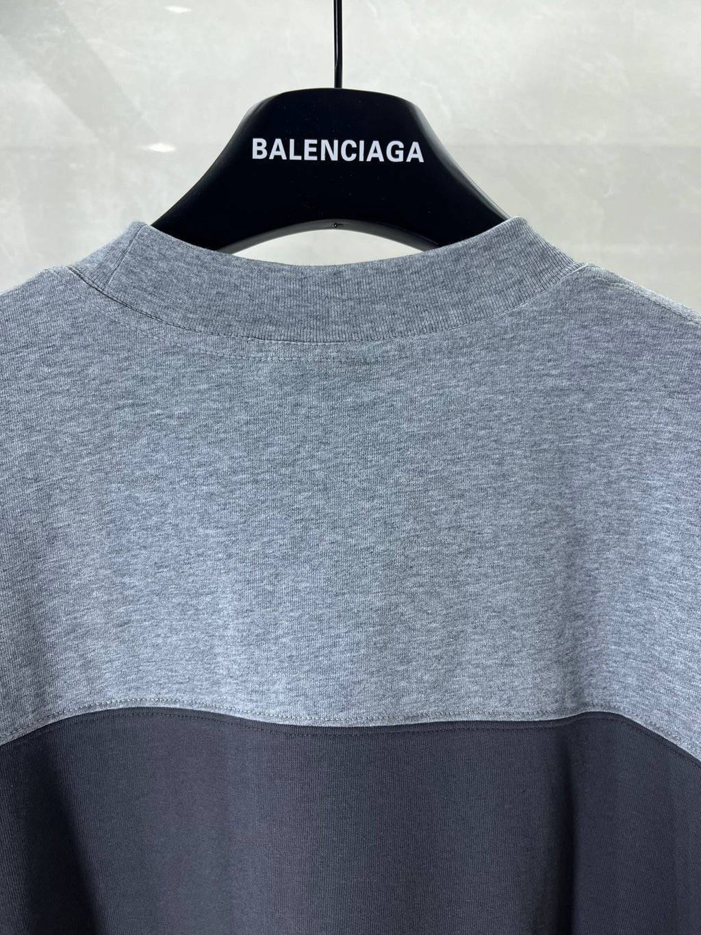 Back of two-tone short-sleeve T-shirt in gray and black with neck logo print