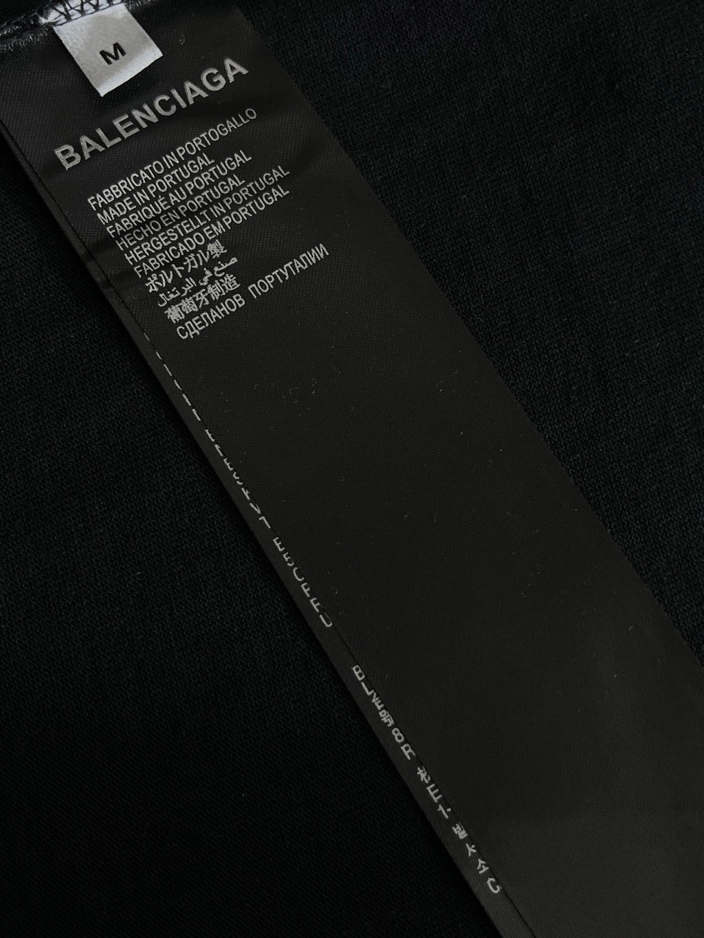 Black garment label with BALENCIAGA text and care instructions