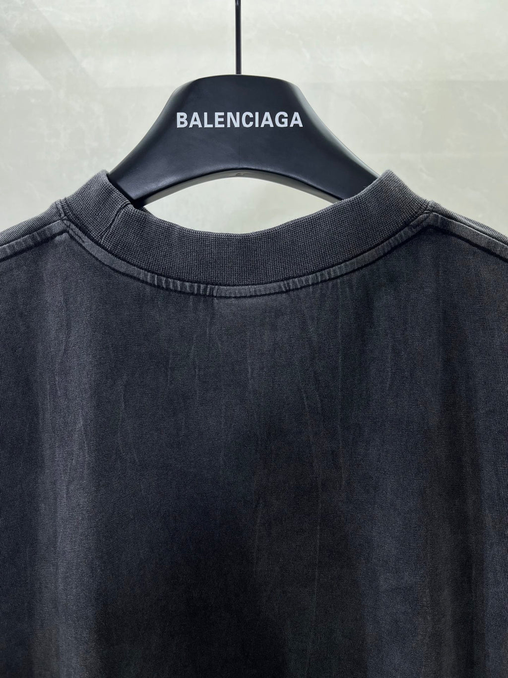 Navy crewneck T-shirt neckline close-up on hanger, plain front.