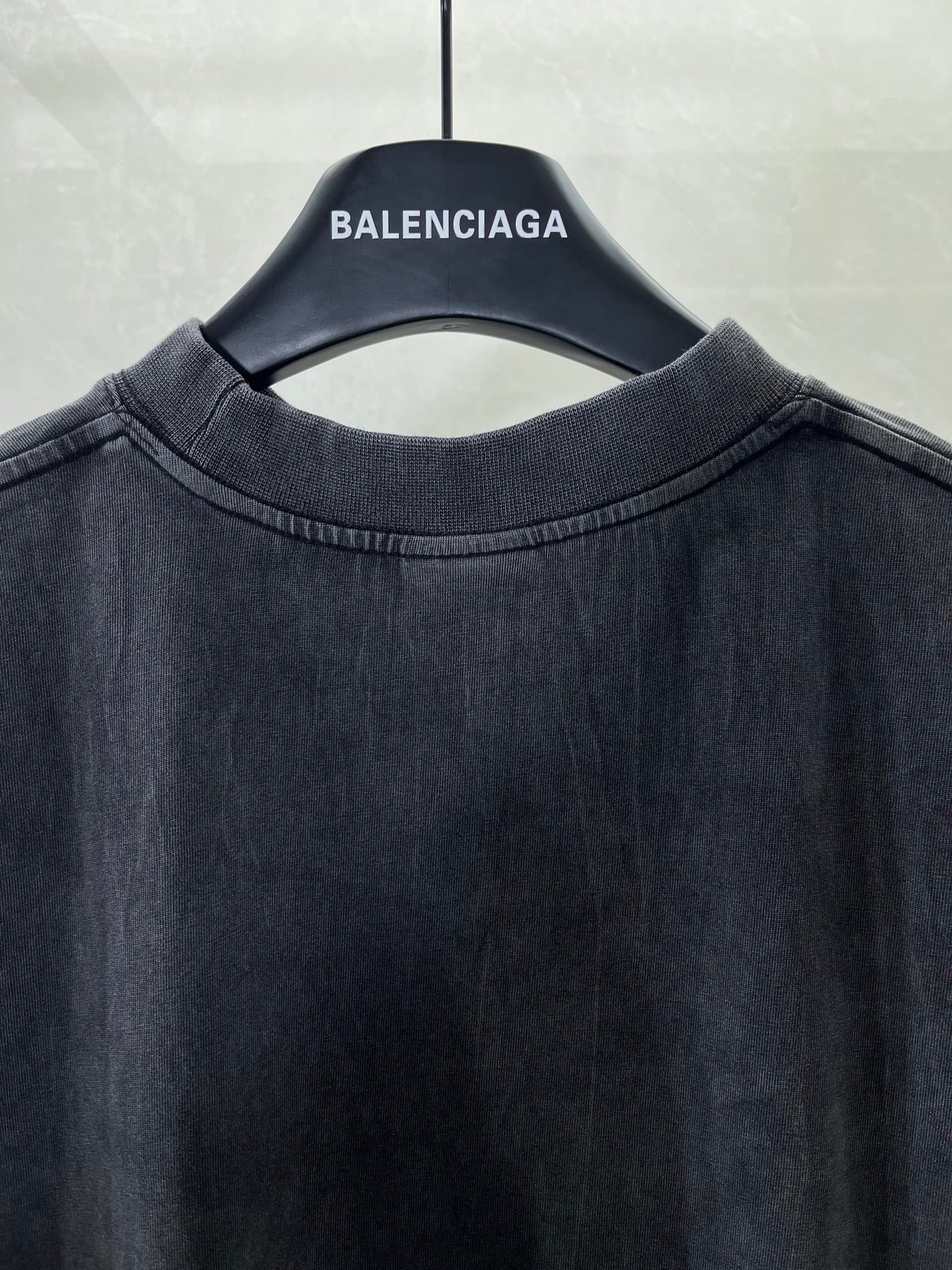 Navy crewneck T-shirt neckline close-up on hanger, plain front.