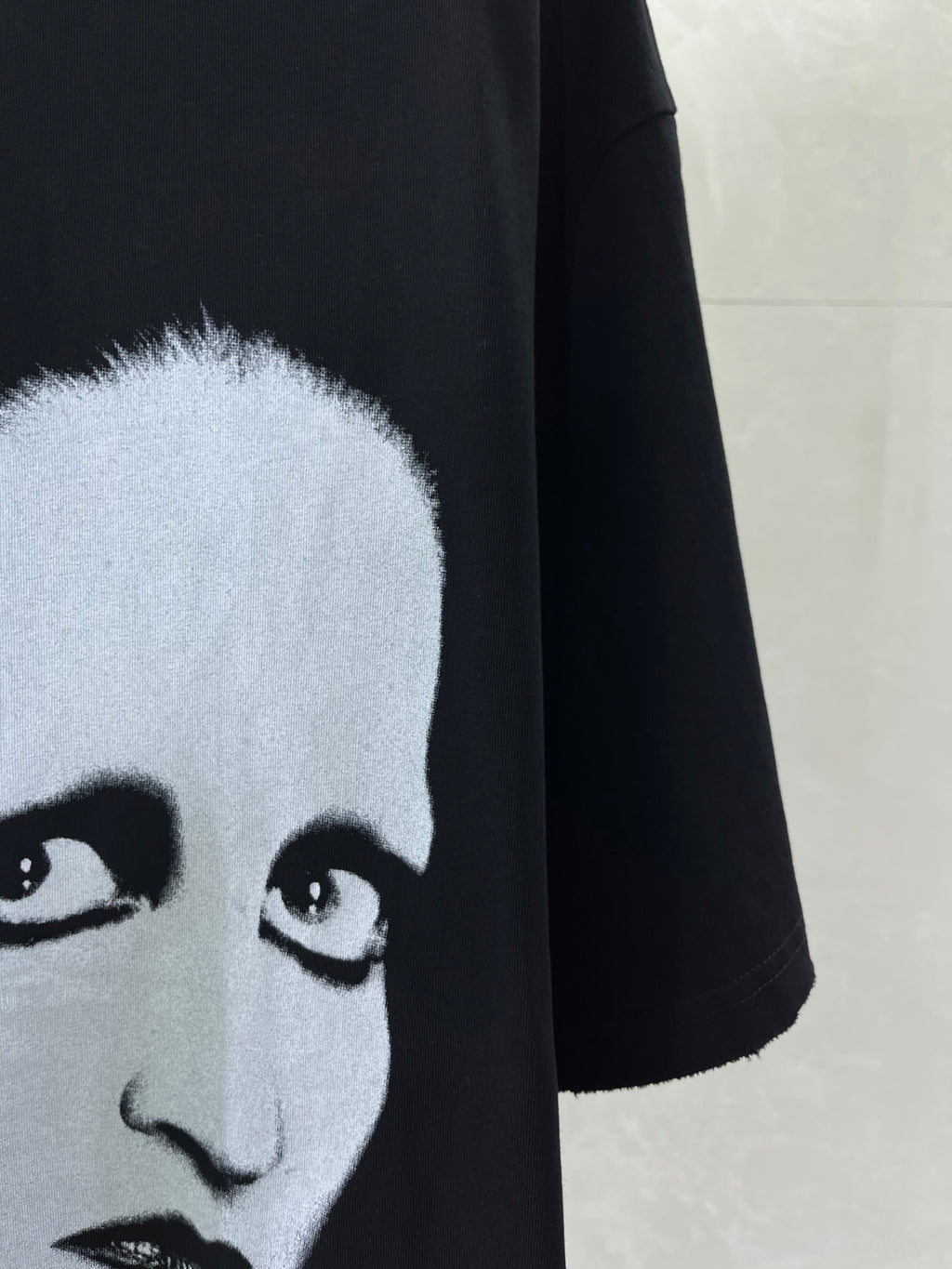 Black short-sleeve T-shirt with close-up of white face eyes graphic