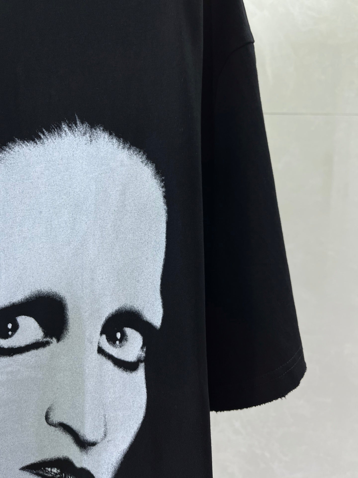 Black short-sleeve T-shirt with close-up of white face eyes graphic