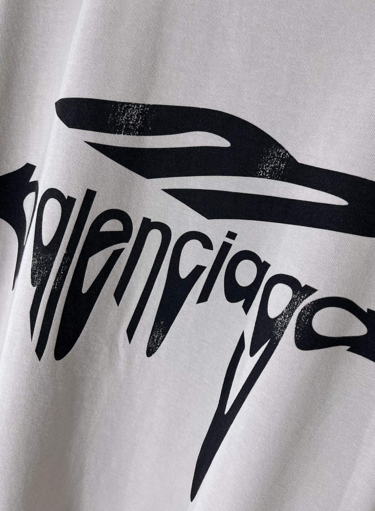 Balenciaga logo T-shirt close-up of black drip lettering print on light gray