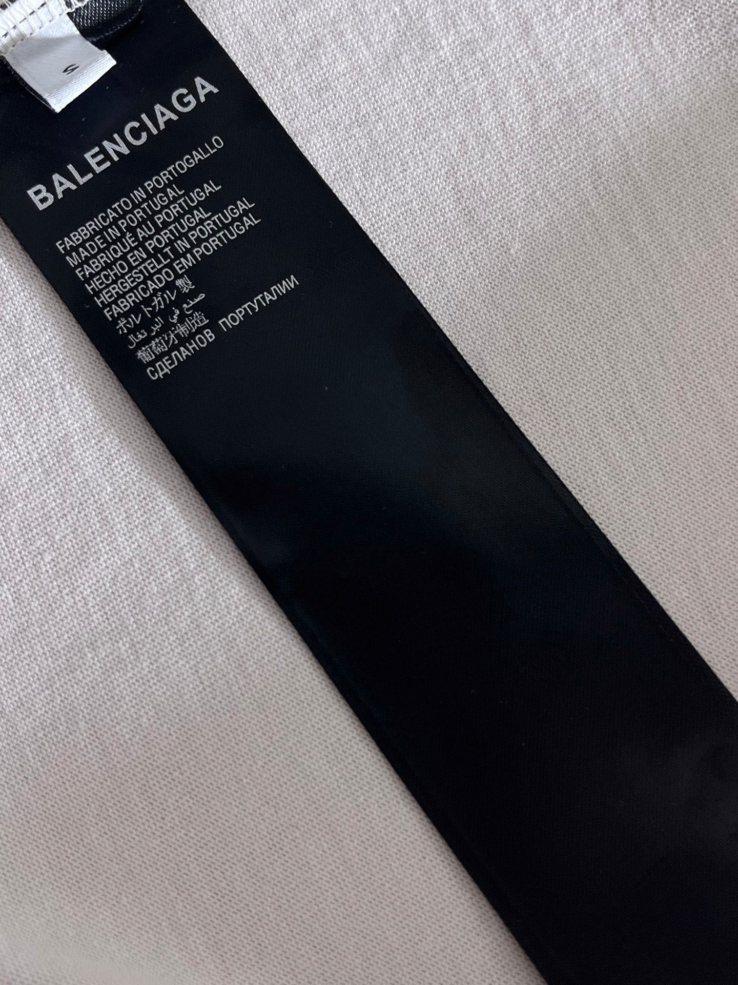 Balenciaga care label tag on inside of T-shirt, black with white text