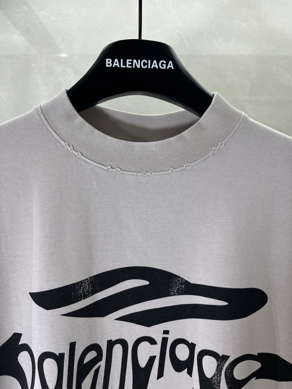 Balenciaga logo T-shirt close-up at crew neckline with black drip graphic