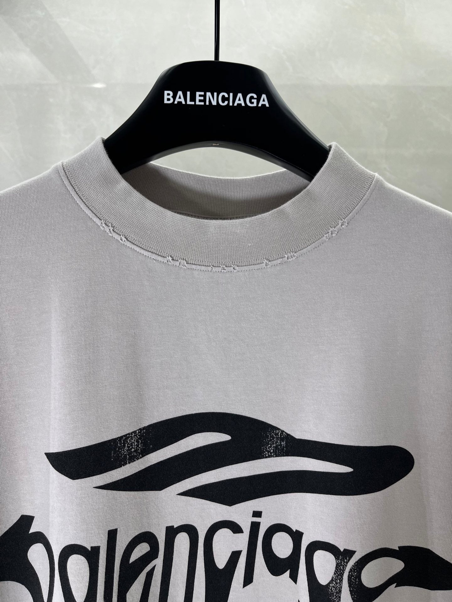 Balenciaga logo T-shirt close-up at crew neckline with black drip graphic