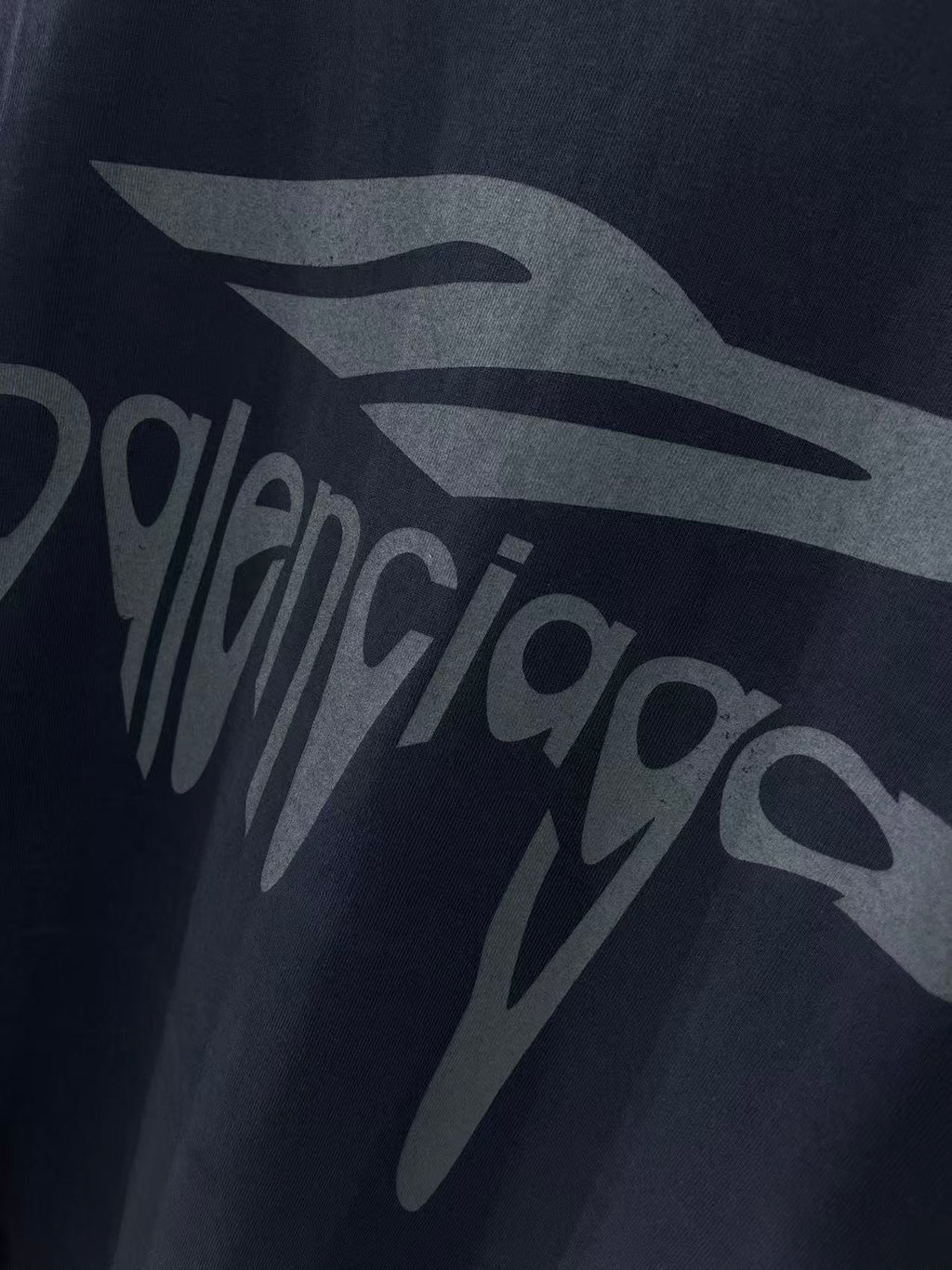Navy Balenciaga T-shirt front logo graphic close-up with partial lettering.