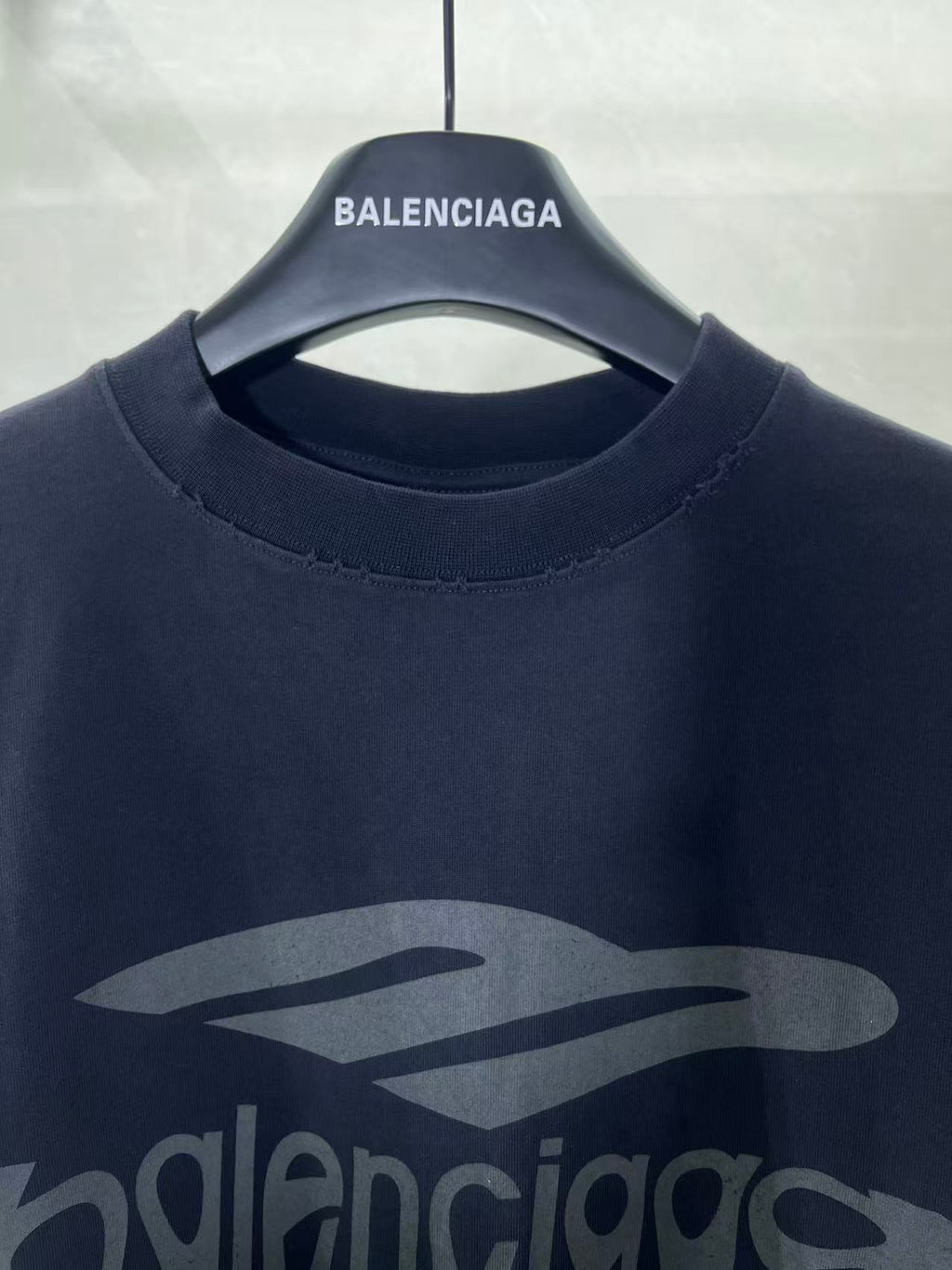 Navy Balenciaga T-shirt crew neck with large front logo graphic close-up.