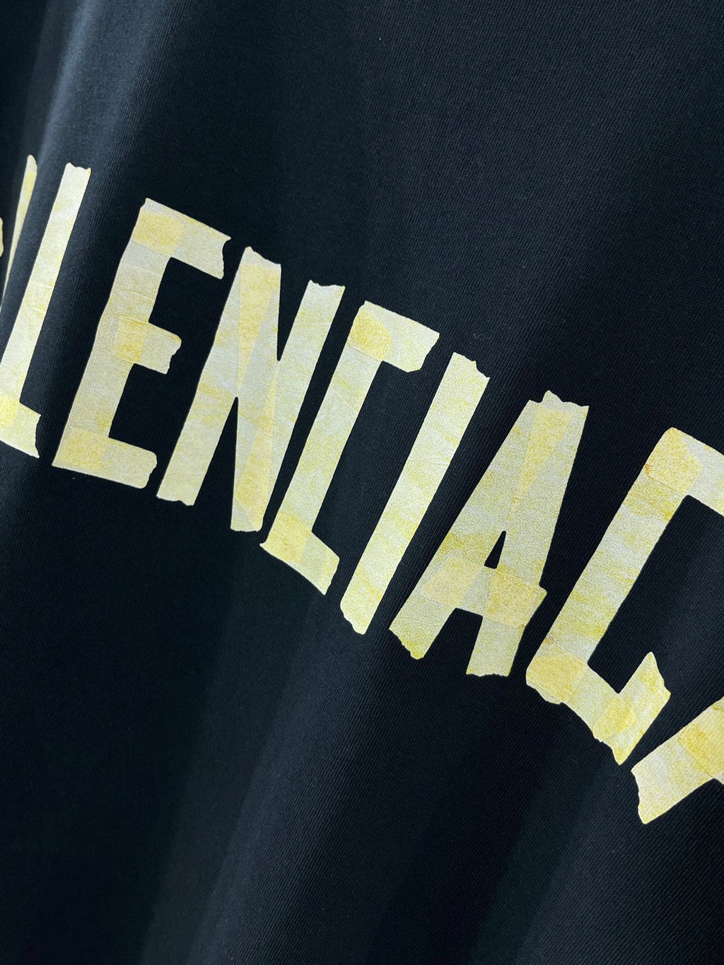 Balenciaga crewneck T-shirt, dark navy, close-up of yellow BALENCIACA-style print