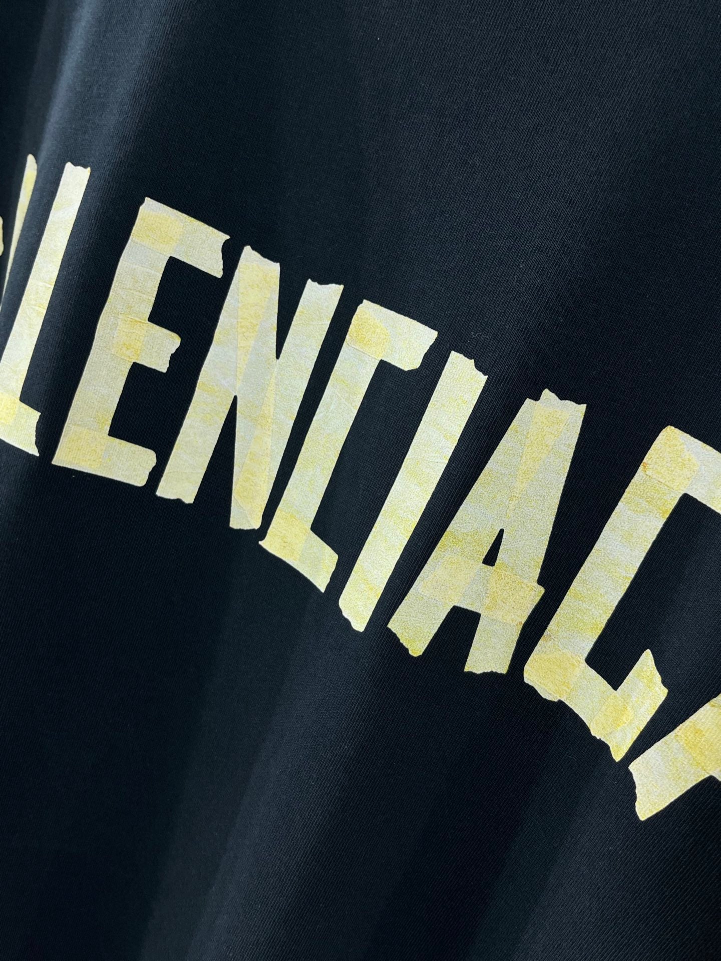 Balenciaga crewneck T-shirt, dark navy, close-up of yellow BALENCIACA-style print