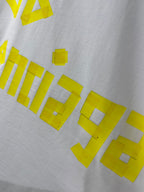 White Balenciaga T-shirt close-up of yellow graphic text across fabric