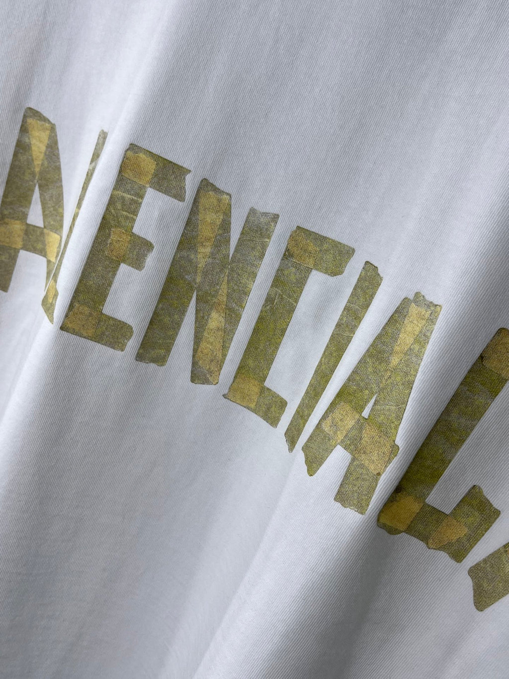 White Balenciaga T-shirt close-up of gold BALENCIAGA lettering print