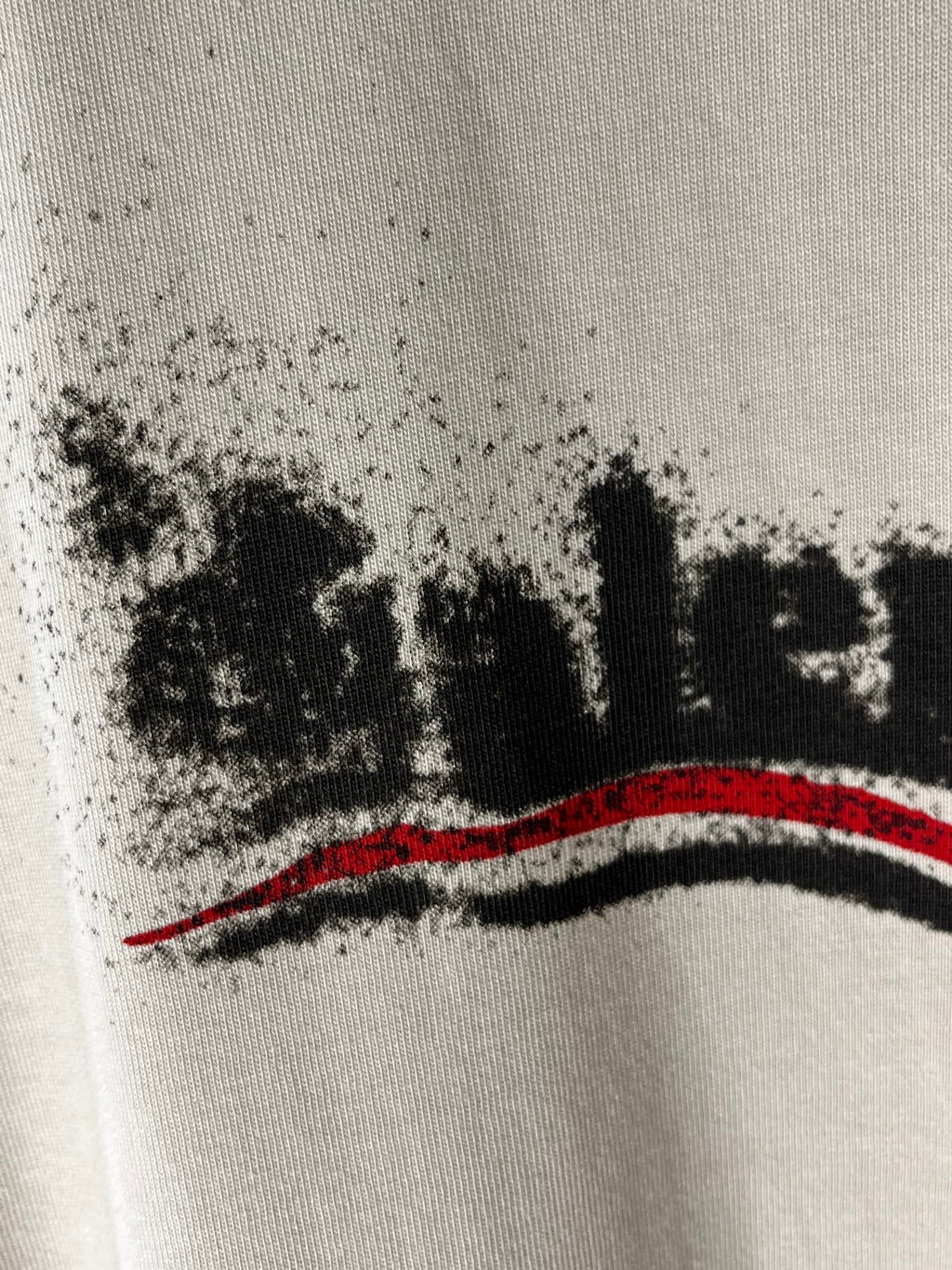 Balenciaga light cream T-shirt close-up of black logo text and red stripe