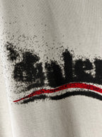 Balenciaga light cream T-shirt close-up of black logo text and red stripe