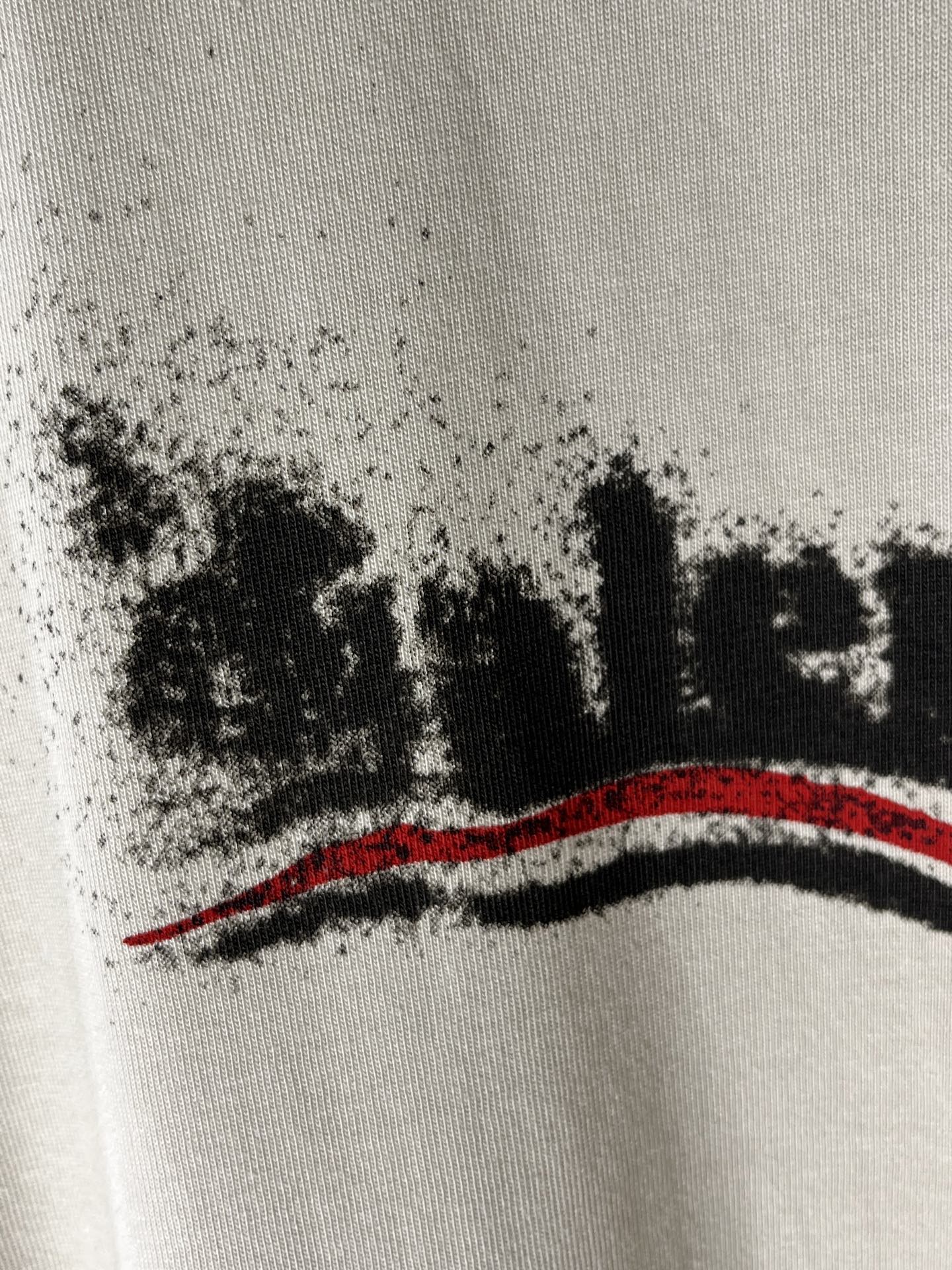 Balenciaga light cream T-shirt close-up of black logo text and red stripe
