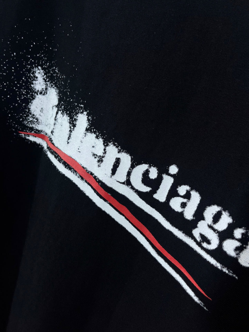 Black T-shirt with distressed white logo letters and red underlining stripe