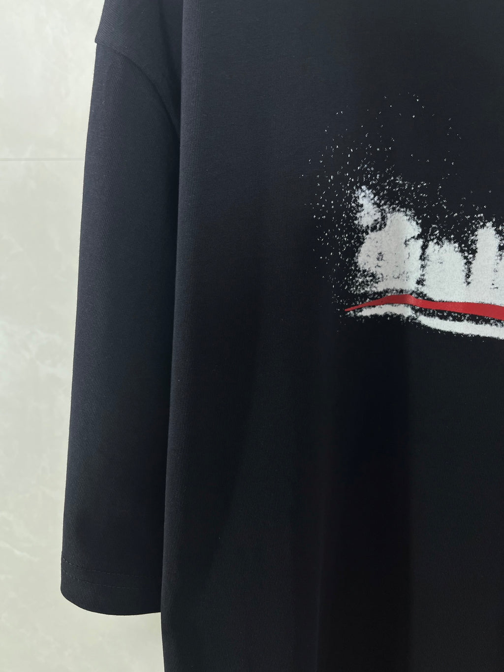 Black T-shirt with distressed white and red logo graphic