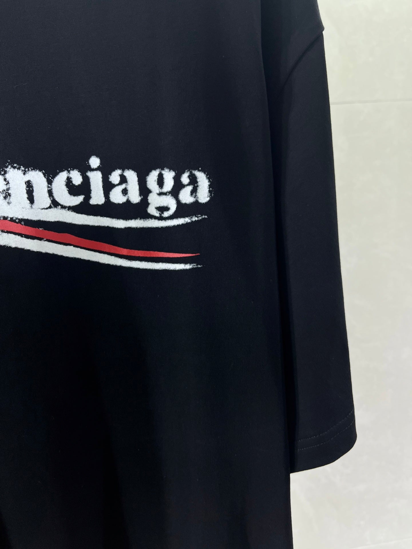 Black T-shirt with white BALENCIAGA text and red stripe graphic