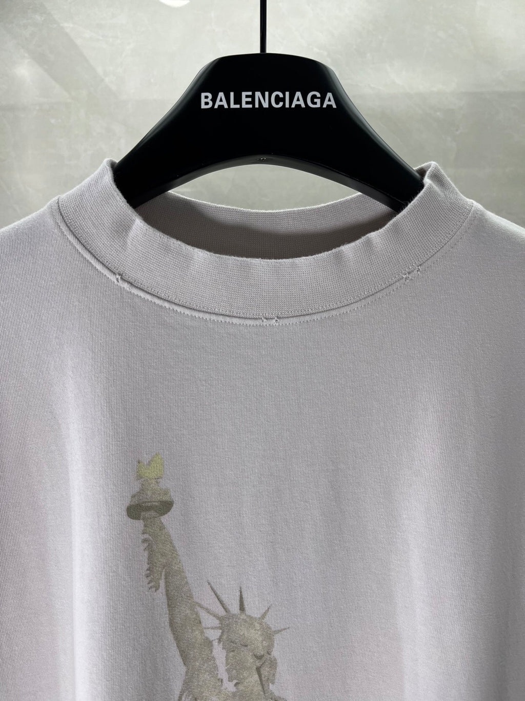 White Balenciaga T-shirt neckline close-up with BALENCIAGA on the hanger tag