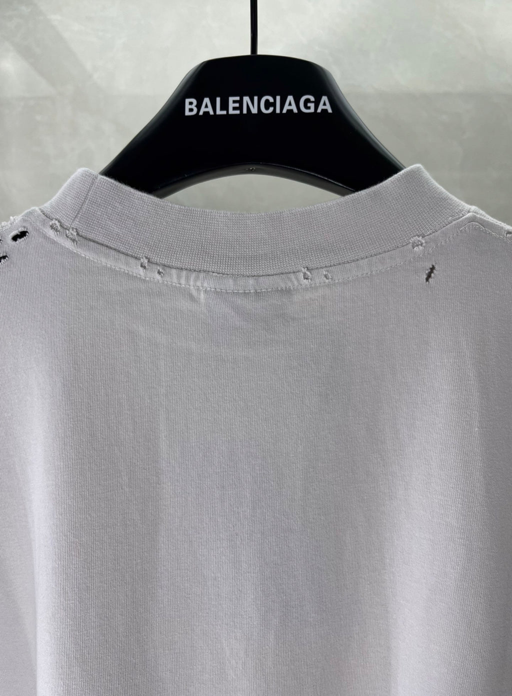 White Balenciaga T-shirt collar close-up with subtle stitching and distressed details