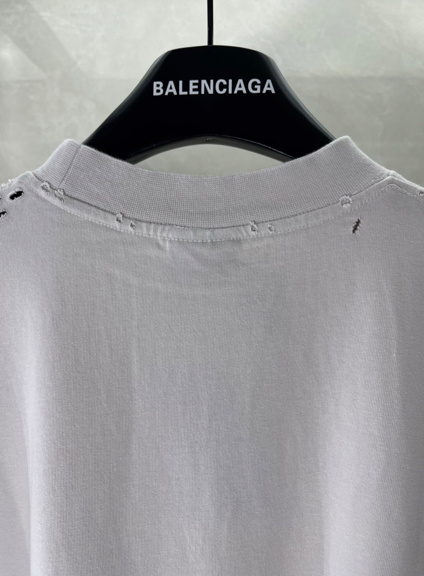 White Balenciaga T-shirt collar close-up with subtle stitching and distressed details