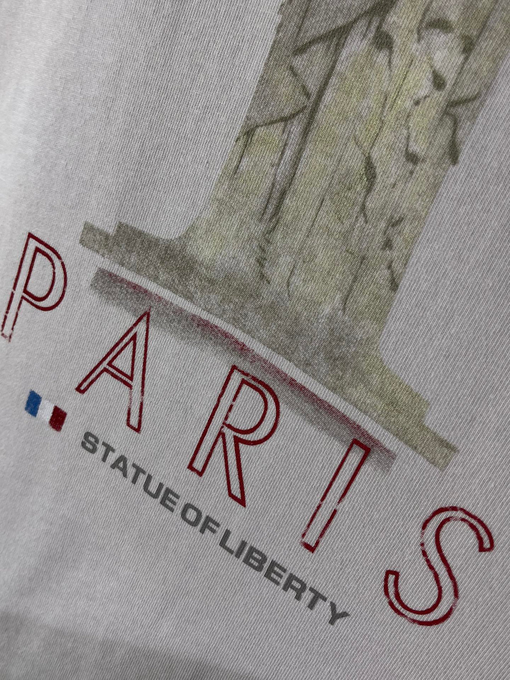 White Balenciaga T-shirt close-up with red PARIS text and Liberty illustration