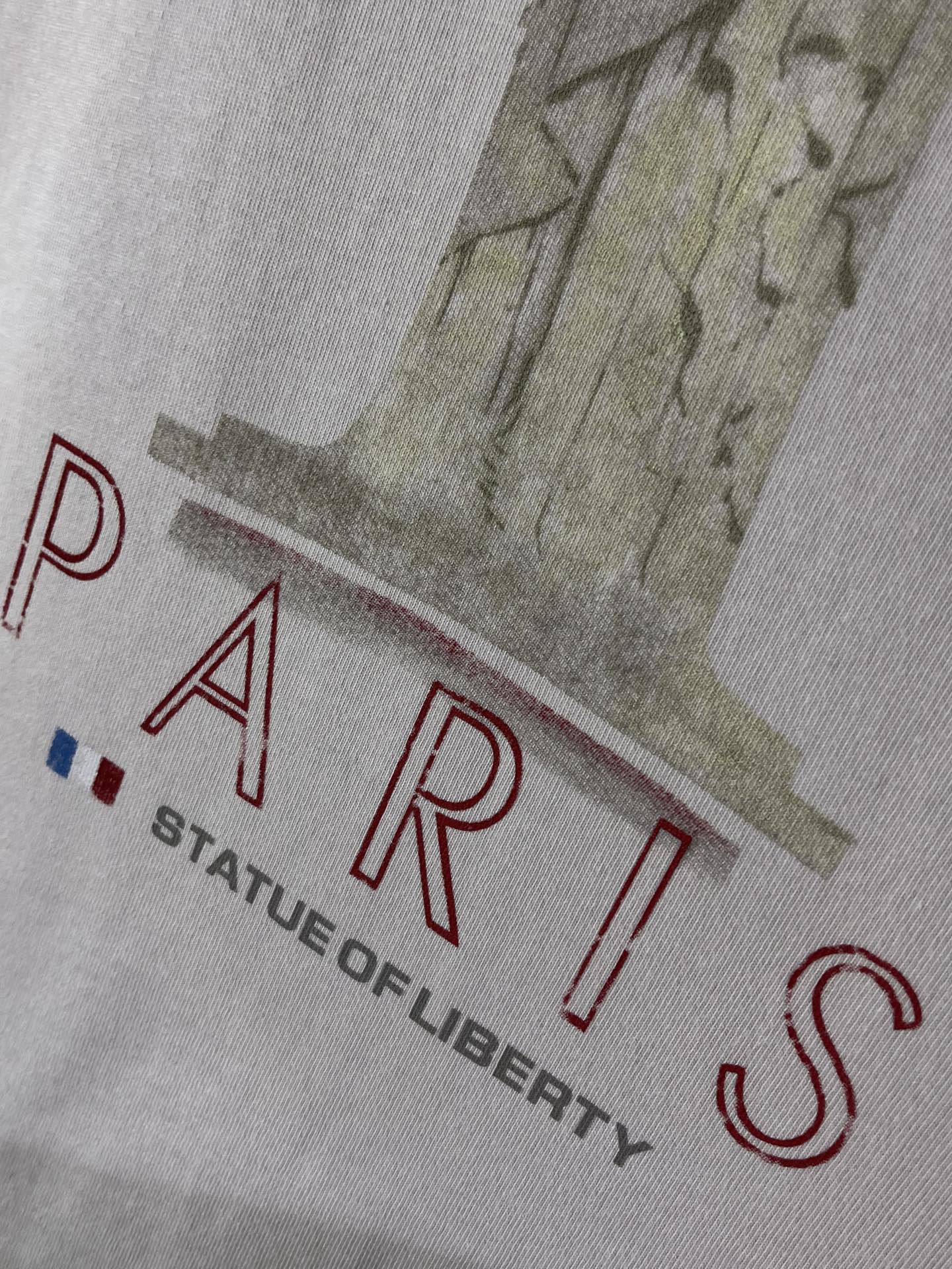 White Balenciaga T-shirt close-up with red PARIS text and Liberty illustration