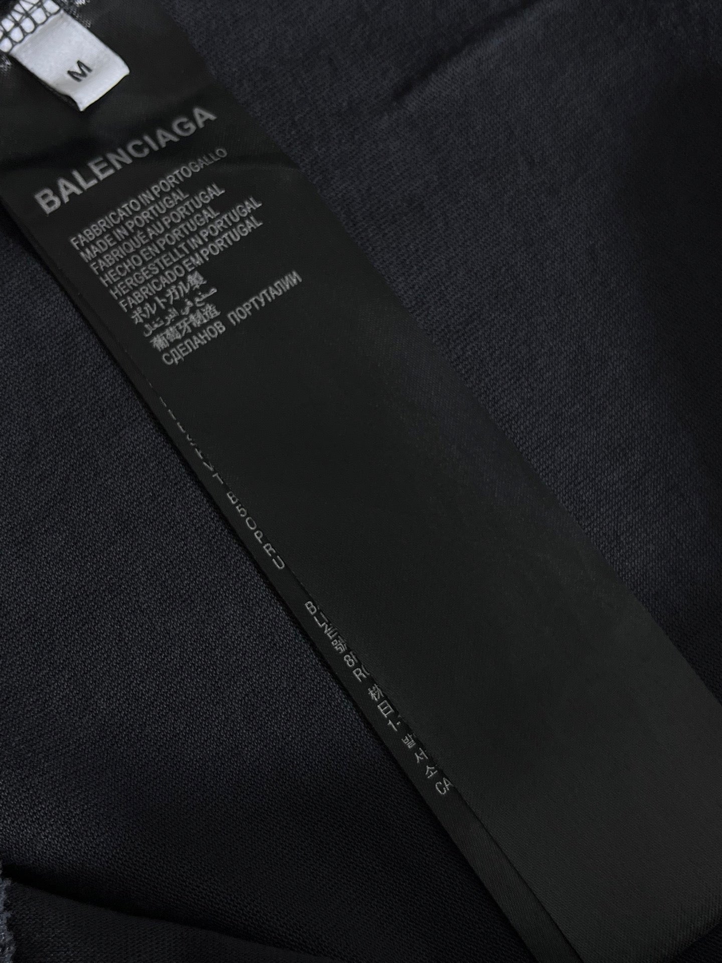 Balenciaga T-shirt care label and size tag on dark fabric