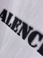 Light lavender Balenciaga T-shirt close-up of black logo print across fabric