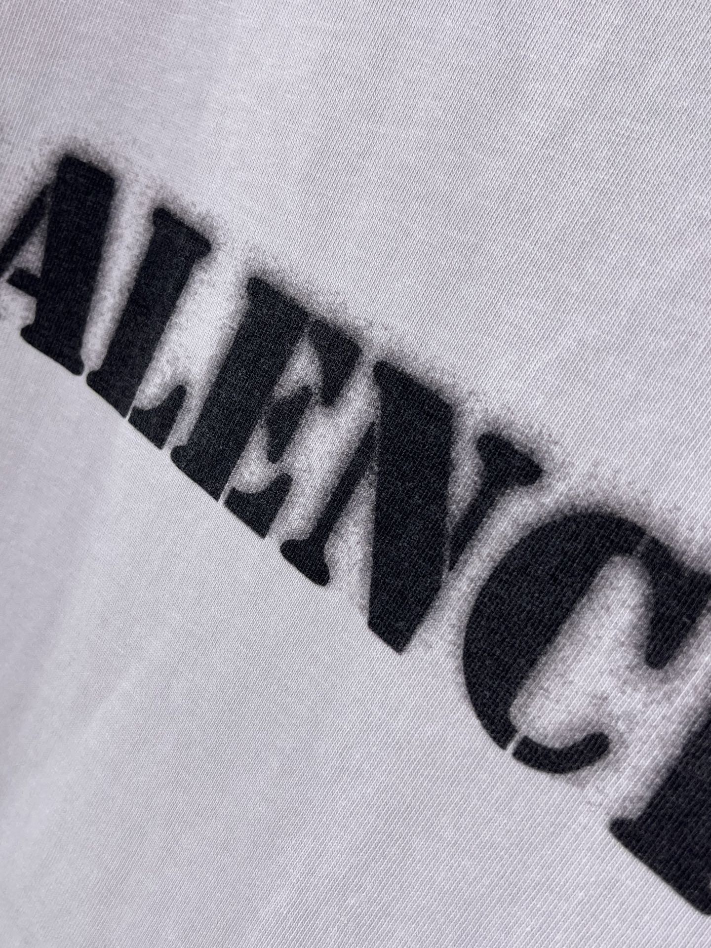 Light lavender Balenciaga T-shirt close-up of black logo print across fabric