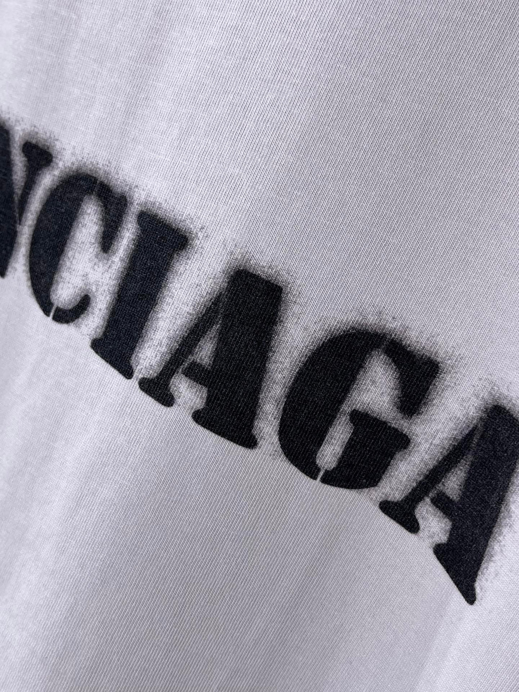 Light lavender Balenciaga T-shirt logo print close-up with bold black letters