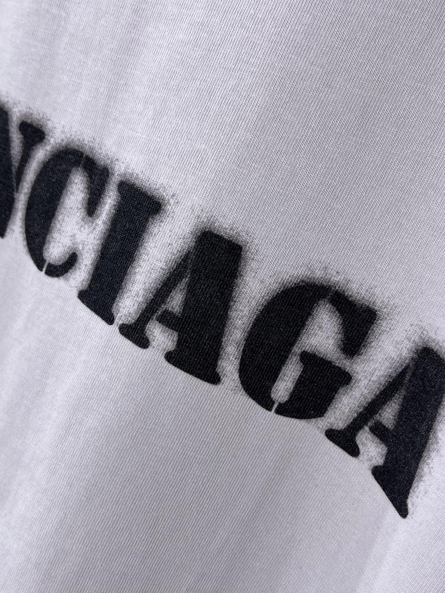 Light lavender Balenciaga T-shirt logo print close-up with bold black letters