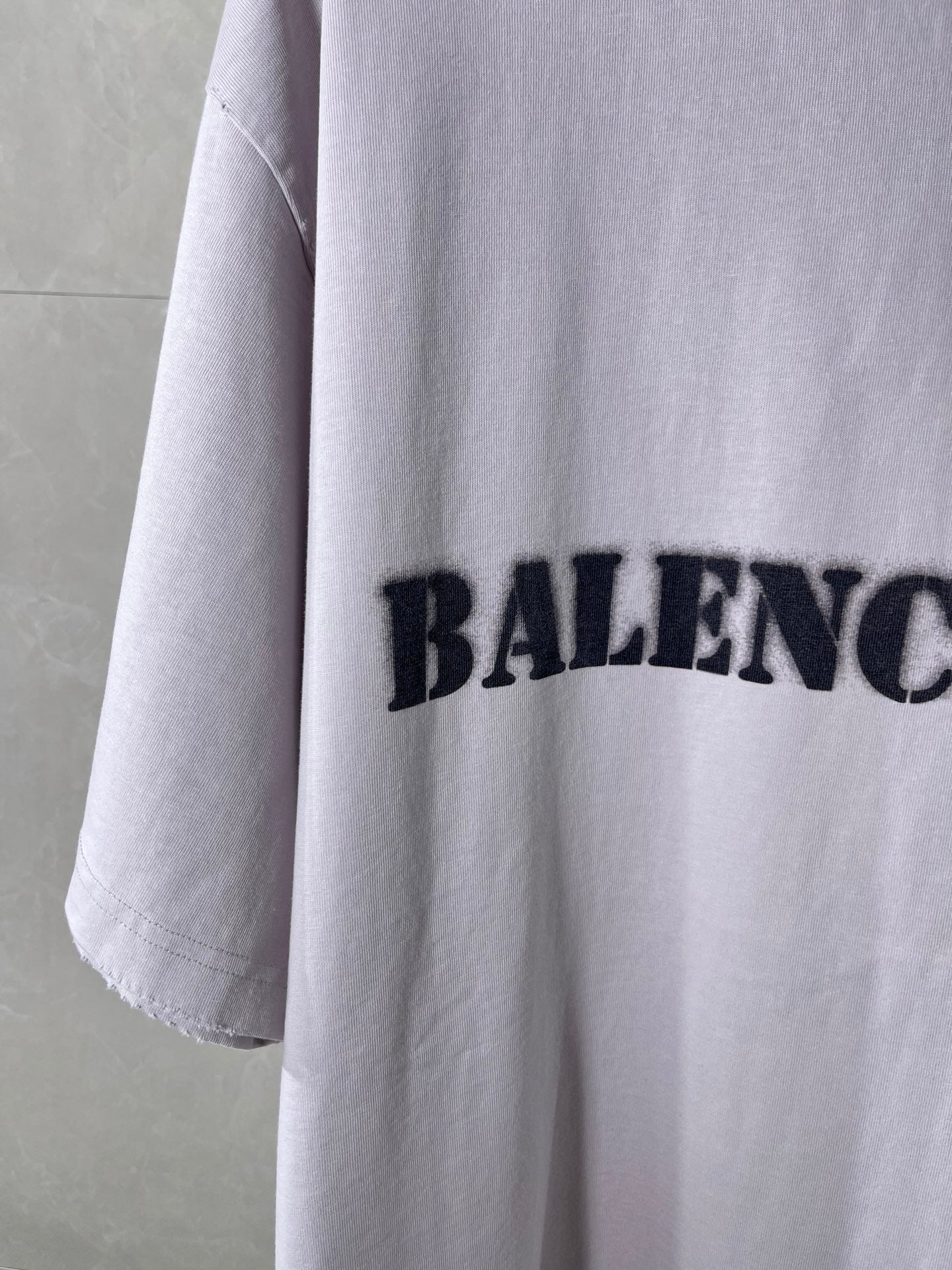 Light lavender Balenciaga T-shirt sleeve with partial black logo print