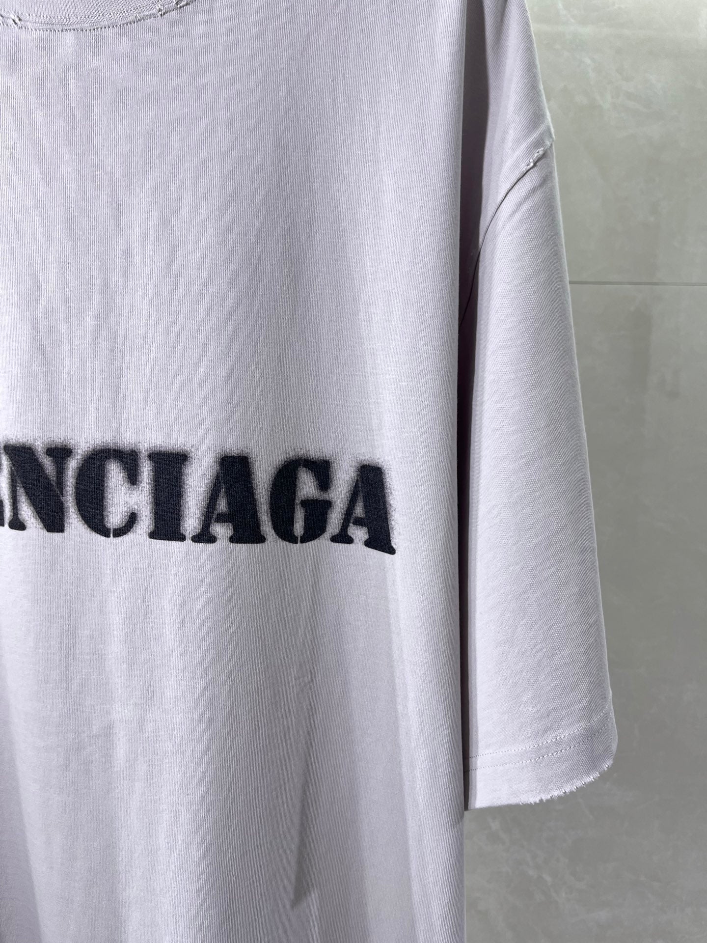 Light lavender Balenciaga T-shirt side hem with partial black logo lettering
