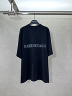Dark short-sleeve T-shirt with BALENCIAGA logo at chest.