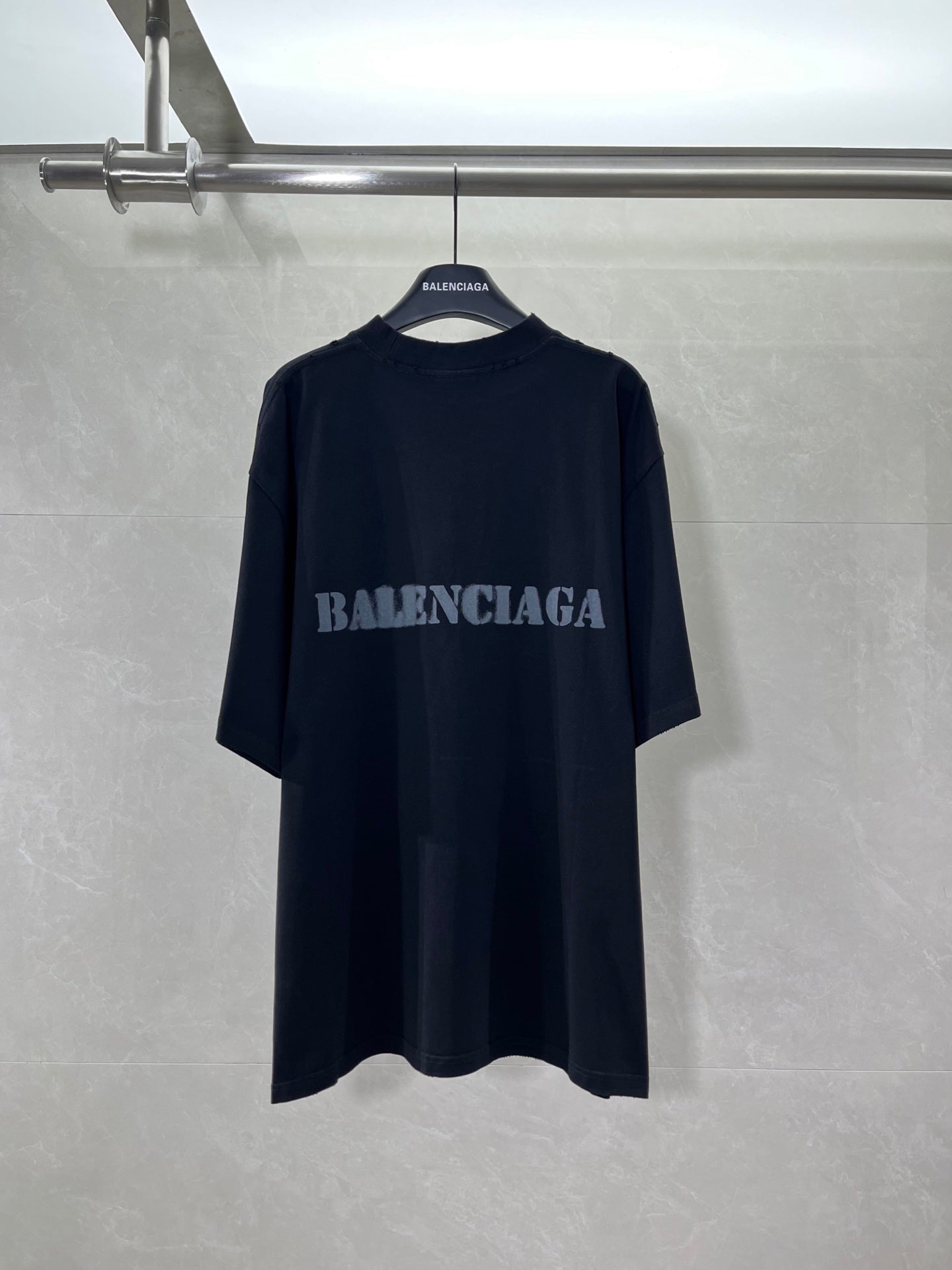 Dark short-sleeve T-shirt with BALENCIAGA logo at chest.