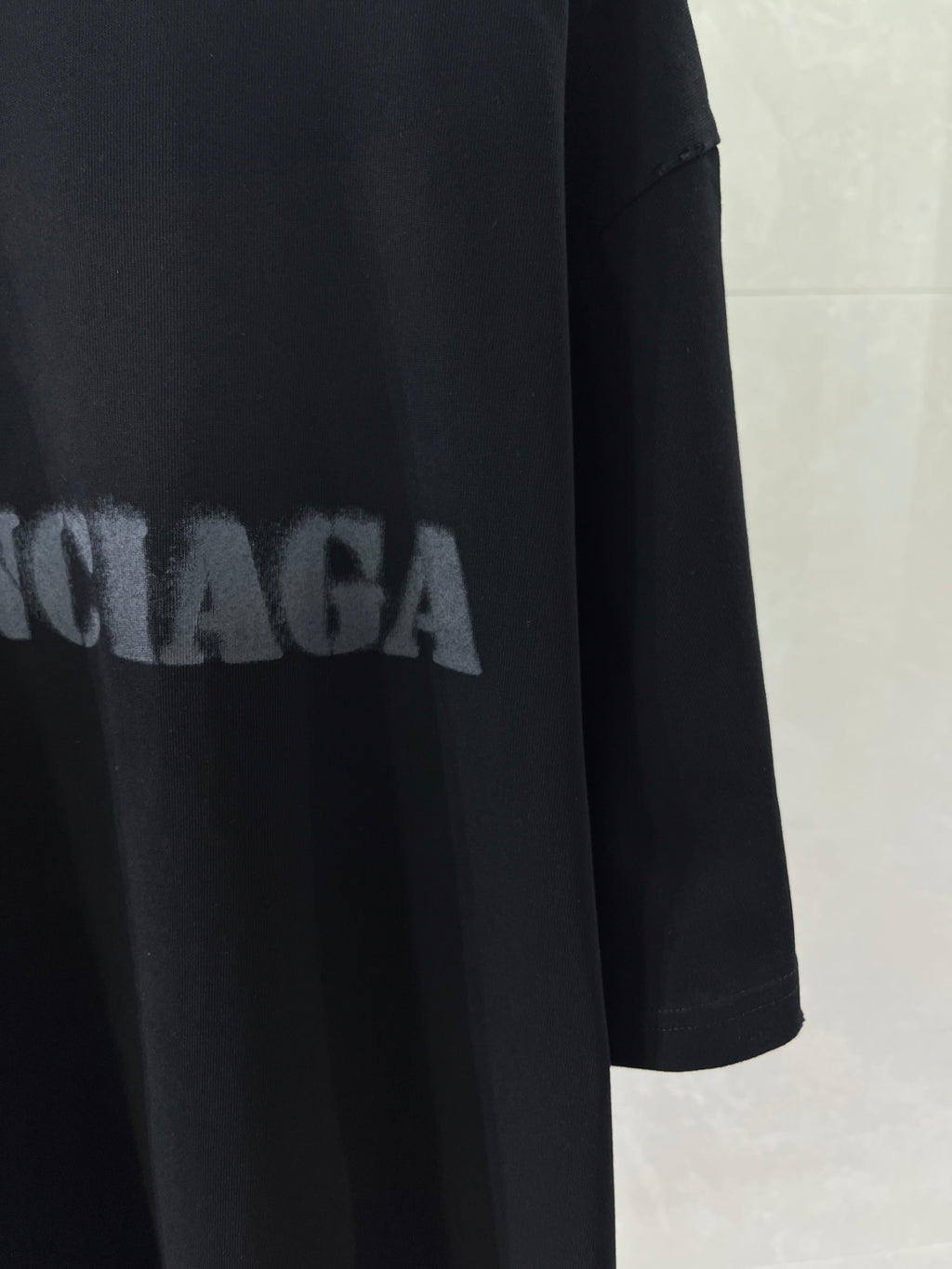Dark T-shirt with partial BALENCIAGA lettering across front.