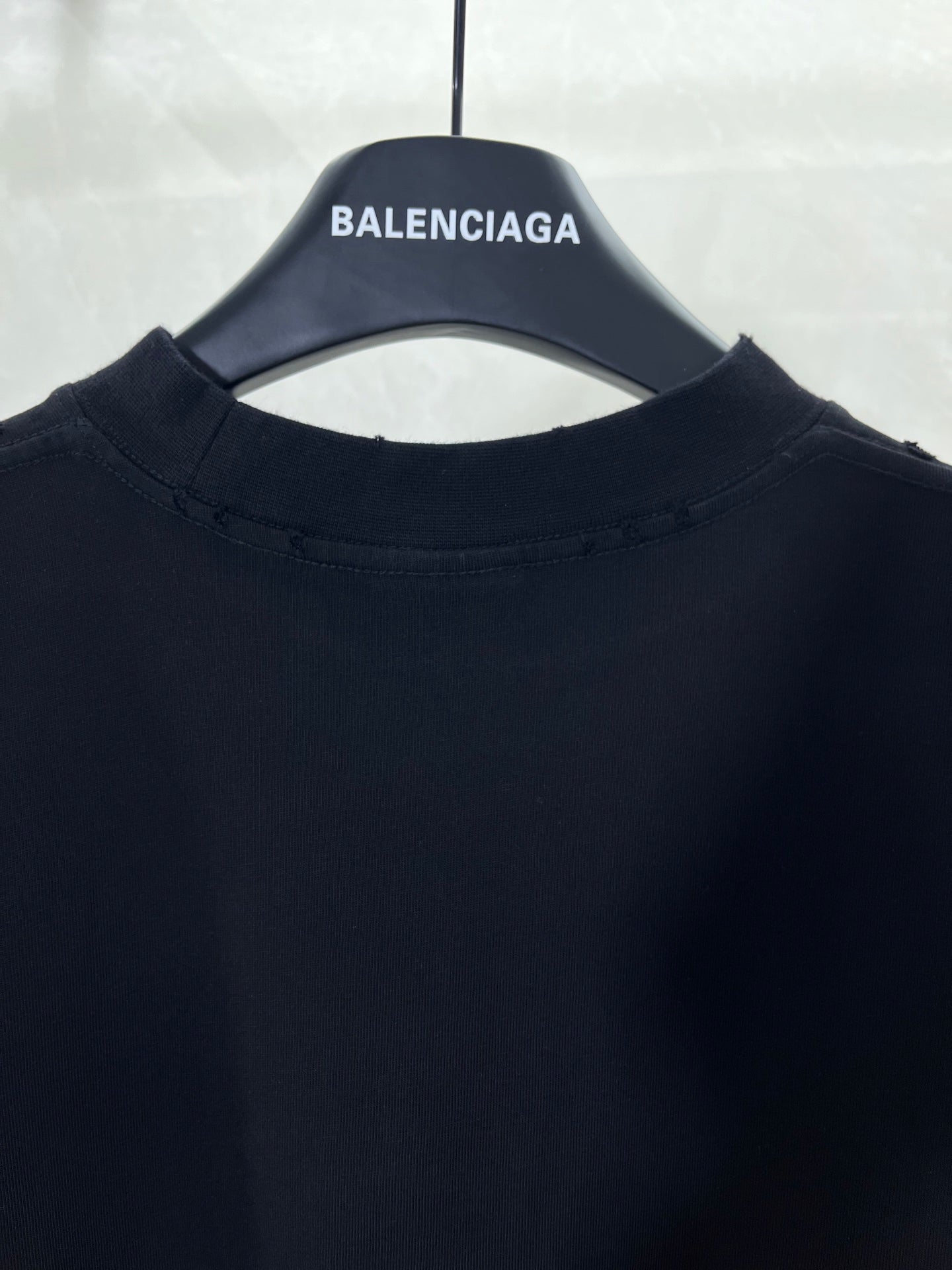 Dark crew-neck T-shirt with BALENCIAGA logo on collar tag.