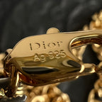 Close-up of Dior gold clasp on a chain bracelet