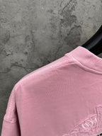 Pink short-sleeve T-shirt back view with partial emblem near shoulder