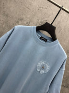 Light blue T-shirt close-up of crew neck and small round crest patch