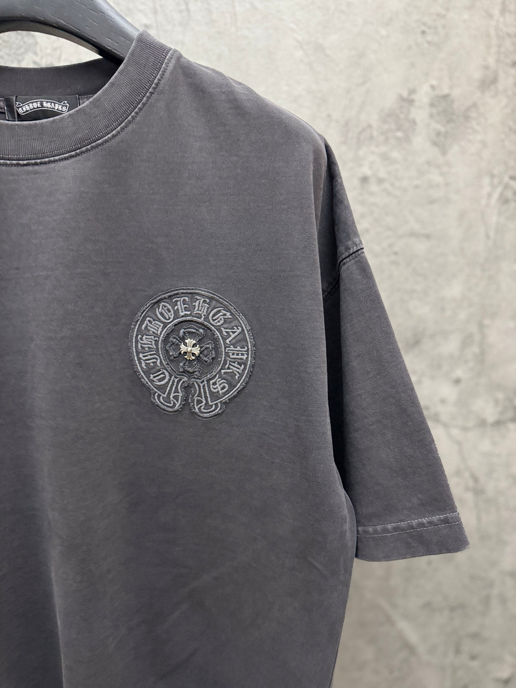 Dark gray crew-neck T-shirt with small circular chest crest logo on front