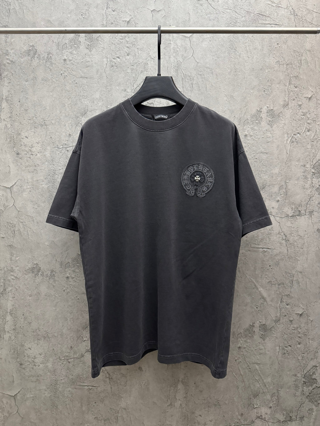 Dark gray crew-neck T-shirt with small circular embroidered chest crest