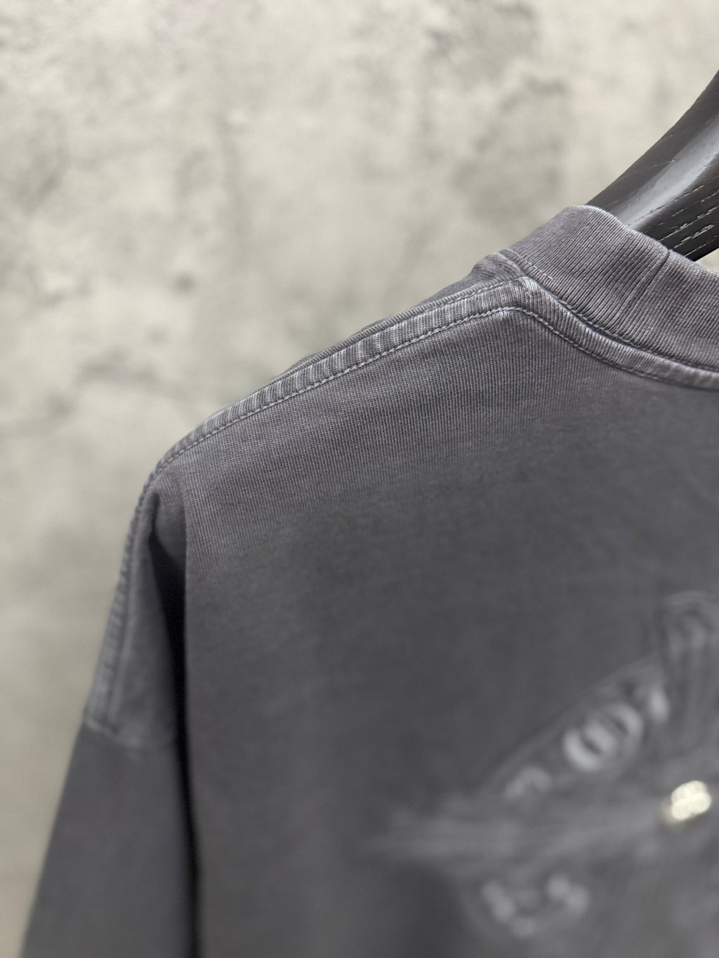 Dark gray T-shirt shoulder seam and crew-neck collar with small logo print
