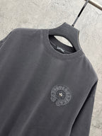 Dark gray crew-neck T-shirt neckline with small circular embroidered chest crest