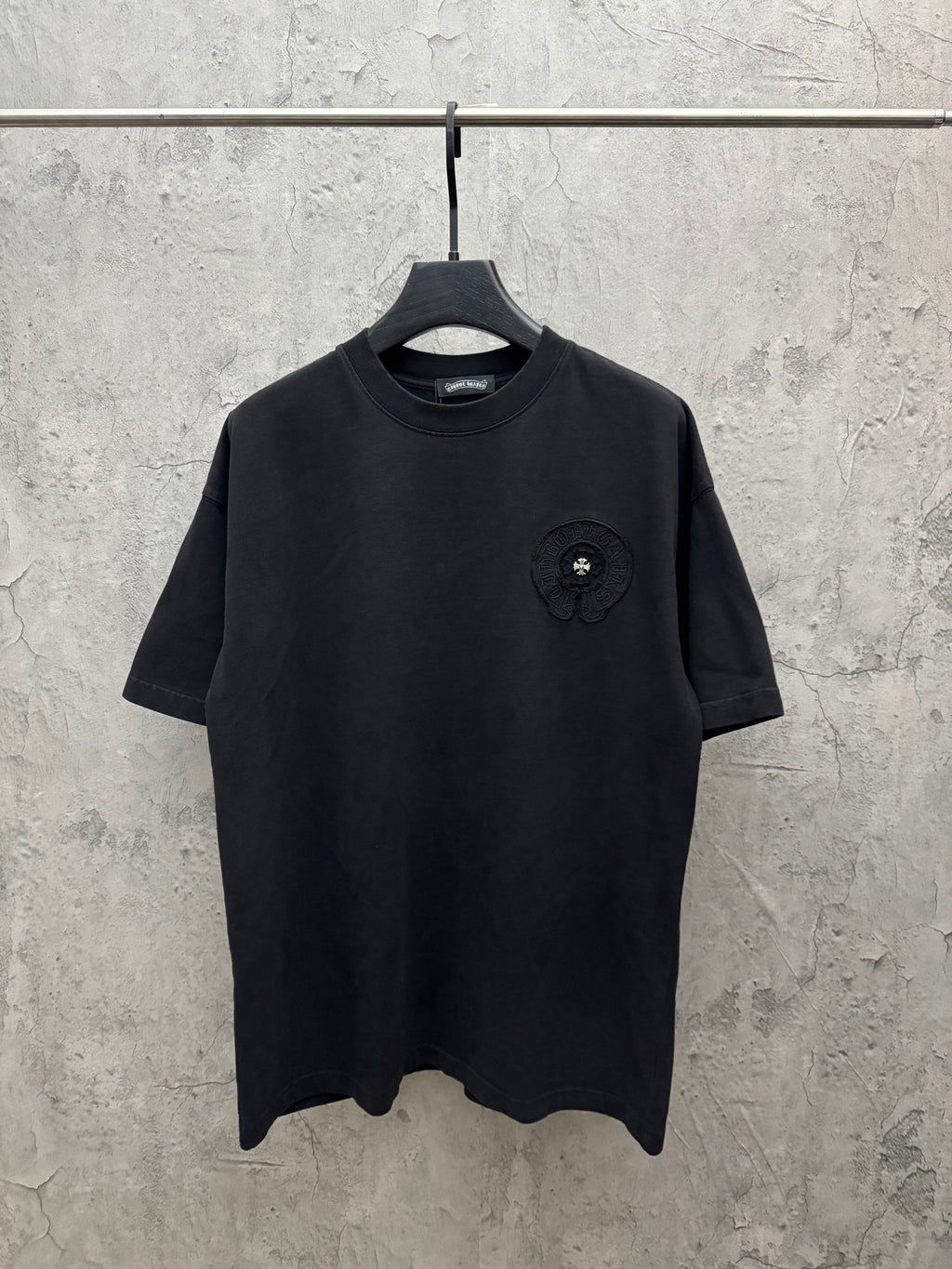 Crewneck short-sleeve T-shirt in dark color with small chest emblem patch