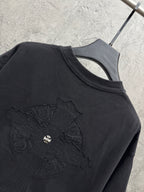 Dark crewneck short-sleeve T-shirt showing embroidered cross graphic detail