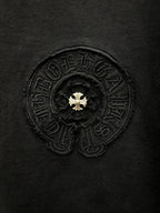 Close-up of embroidered circular emblem on dark T-shirt front