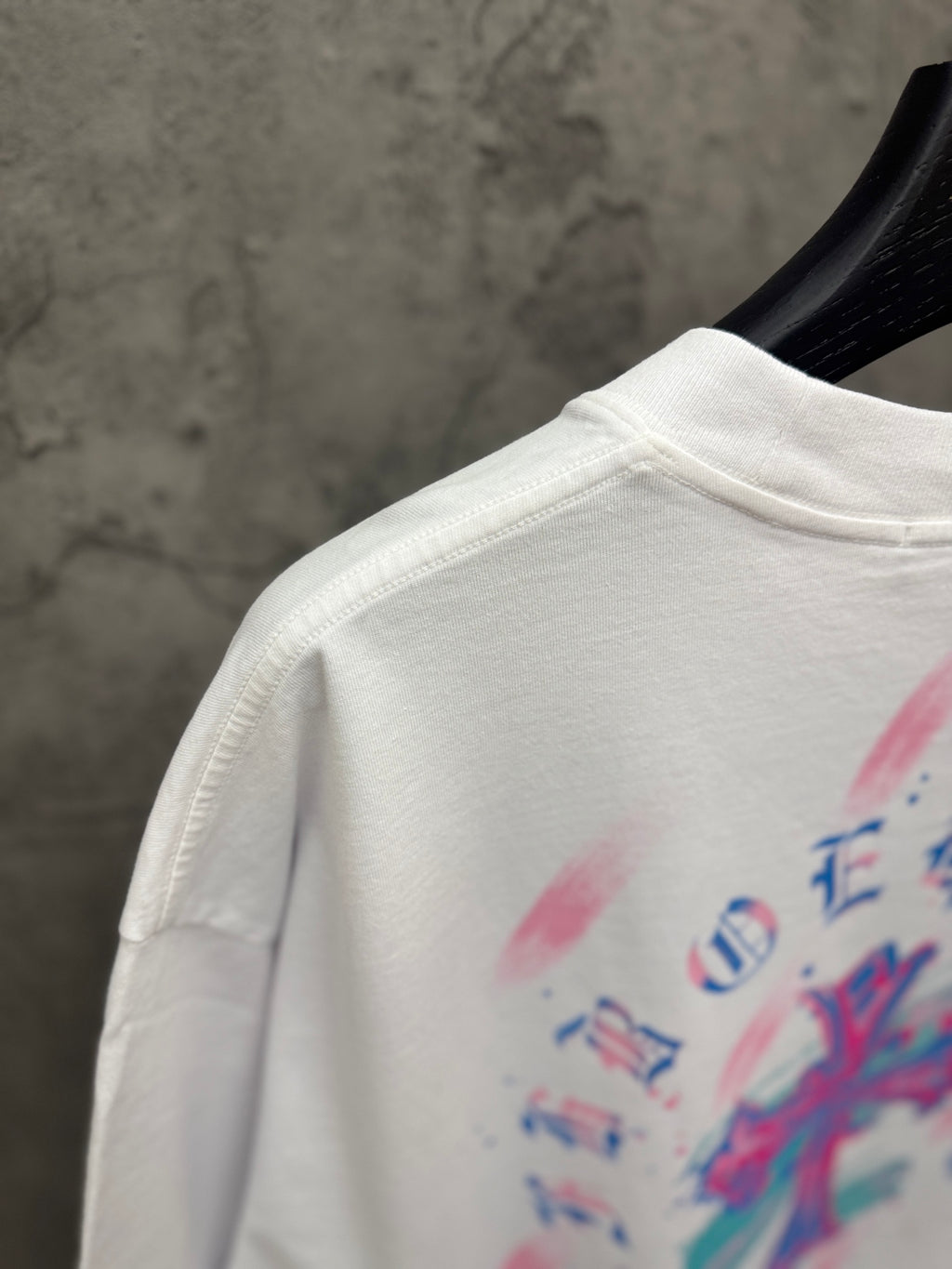 White T-shirt shoulder with crew neck seam and partial back graphic