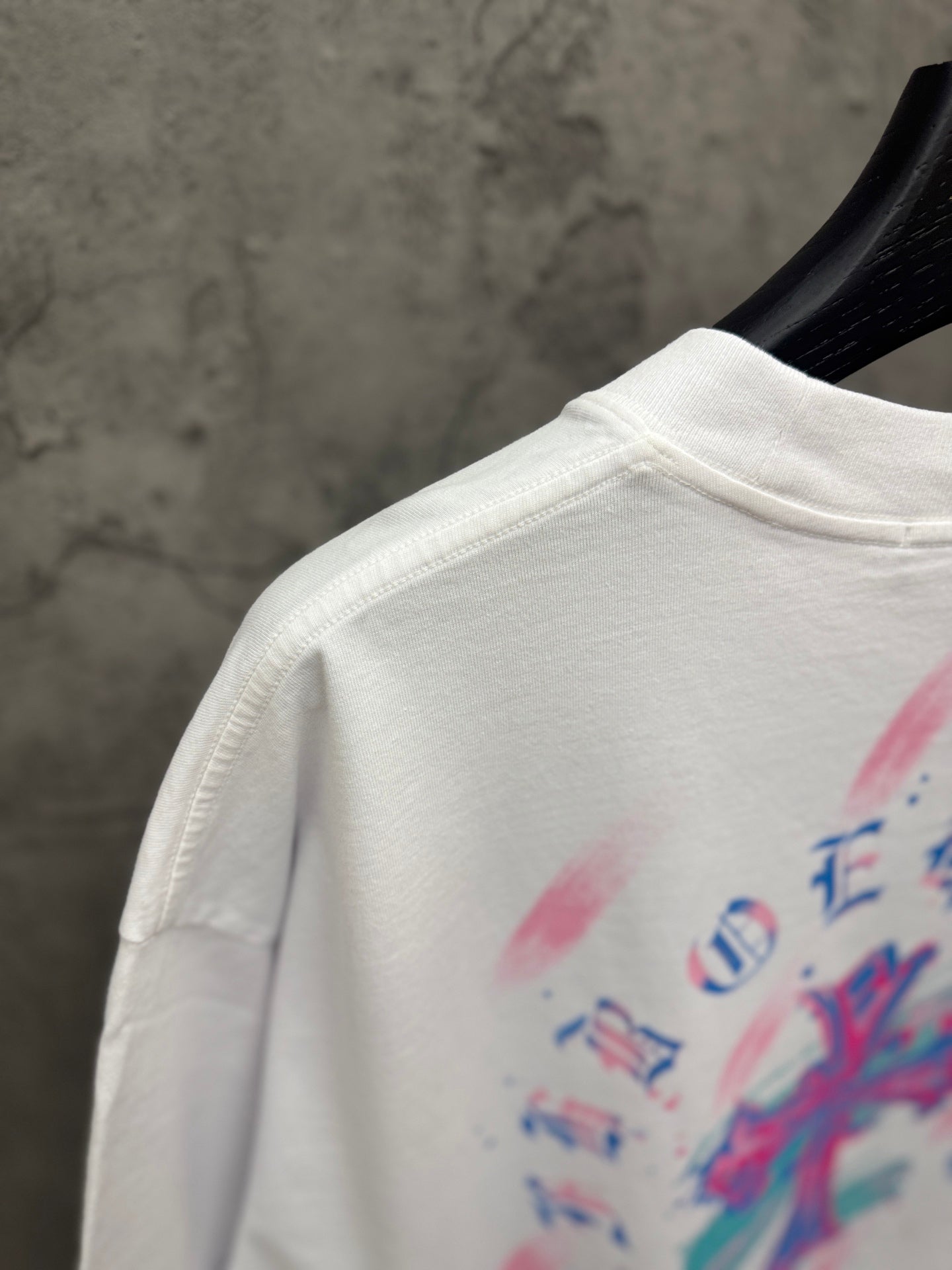 White T-shirt shoulder with crew neck seam and partial back graphic